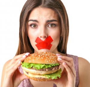 Woman with tied mouth holding hamburger isolated on white